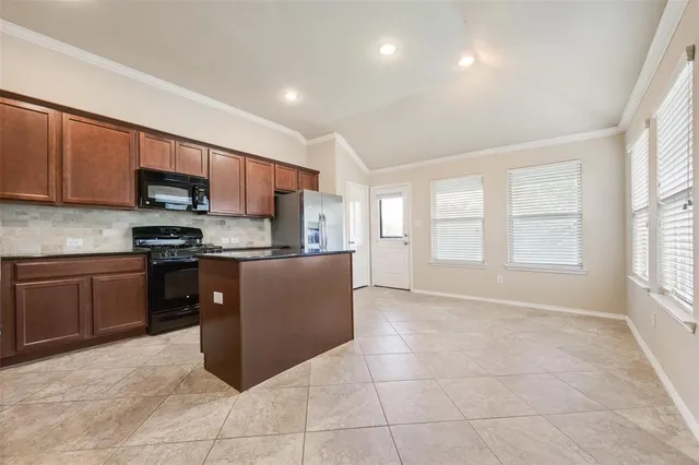 a kitchen with stainless steel appliances granite countertop a stove a sink a refrigerator a microwave oven and a refrigerator