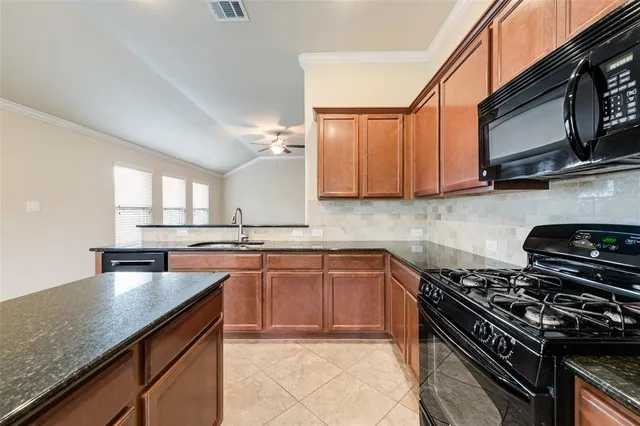 a kitchen with stainless steel appliances granite countertop a sink stove and microwave