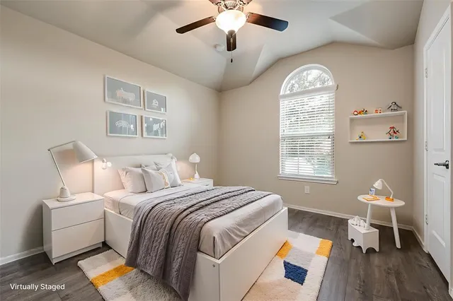 a spacious bedroom with a bed and a chandelier