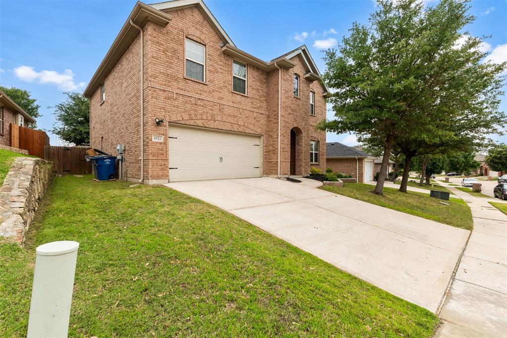 6522 Portside Ridge Lane Dallas, TX 75249 - Photo 4 of 37 Two-story brick exterior featuring a multi-car garage, arched entry, and established landscaping