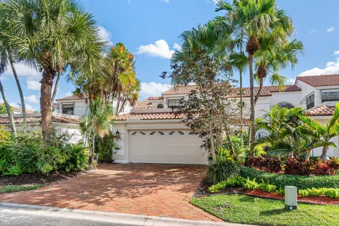 a sign board with flower plants and wooden fence