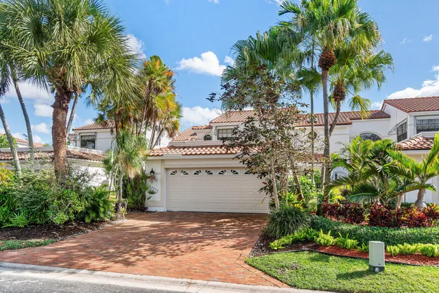 a sign board with flower plants and wooden fence