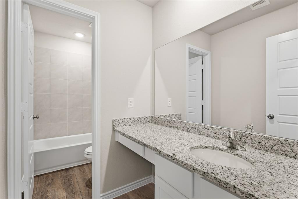 10608 Brocket Lane Crowley, TX 76036 - Photo 18 of 40 a bathroom with a granite countertop sink and a mirror