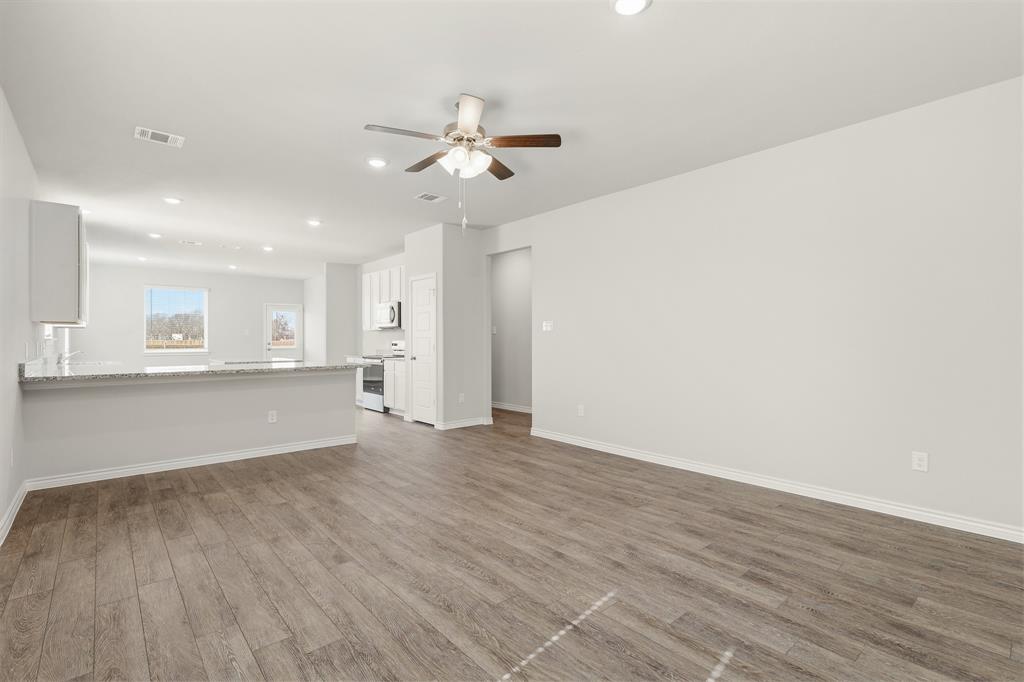 10608 Brocket Lane Crowley, TX 76036 - Photo 4 of 40 a view of an empty room with wooden floor and a window
