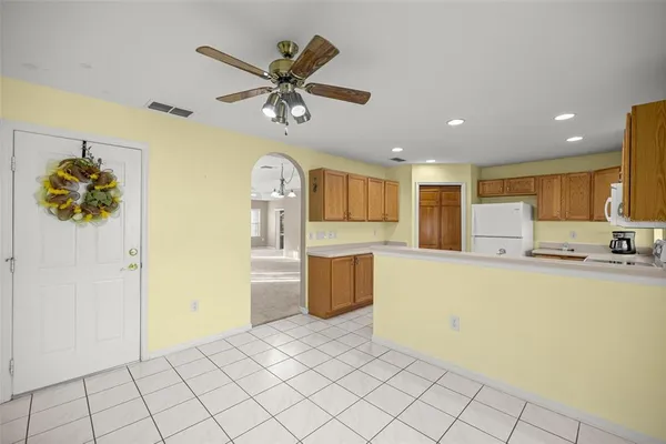 a view of a kitchen with furniture and a refrigerator