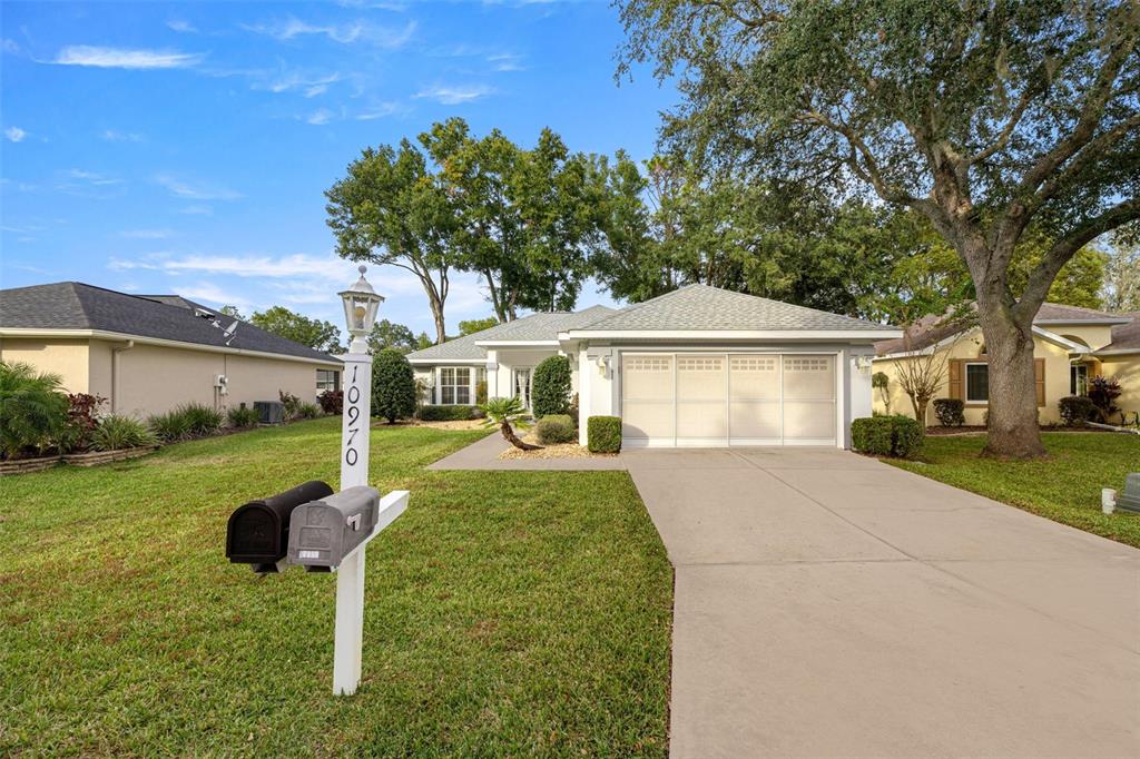10970 Southwest 69th Circle Ocala, FL 34476 - Photo 27 of 50 a front view of a house with a yard and porch