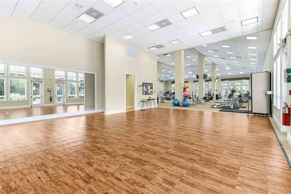 a view of a living room with floor to ceiling window and wooden floor