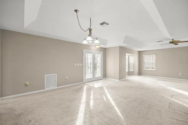 a view of a big room with windows and chandelier