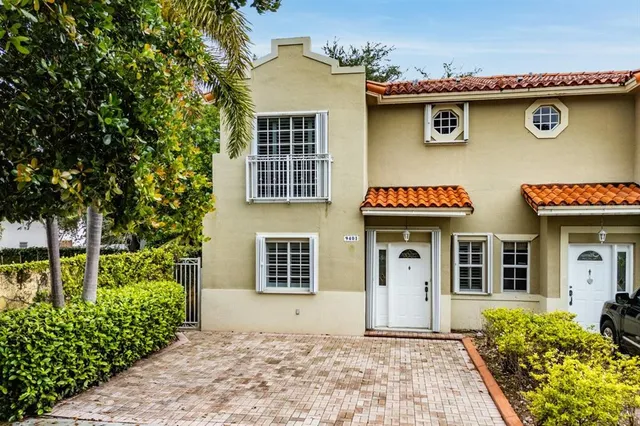 a front view of a house with a yard and trees