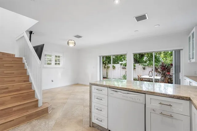 a kitchen that has a lot of cabinets in it and wooden floor