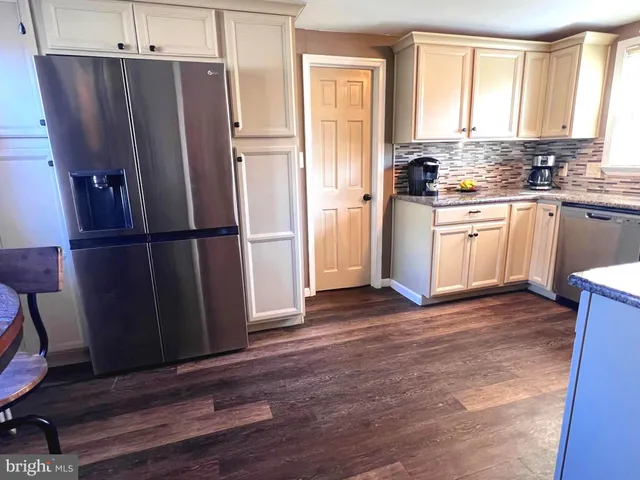 a view of a hallway with wooden floor and door