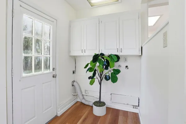 a plant in a vase with white cabinets