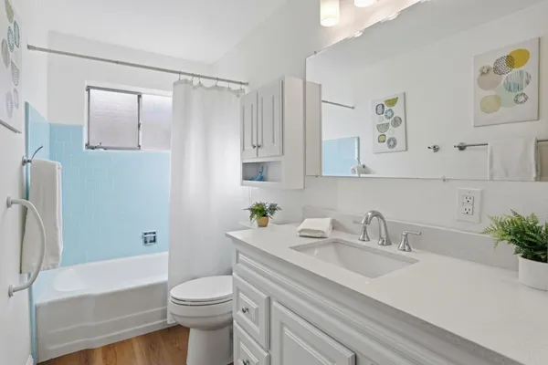 a bathroom with a sink a toilet and shower