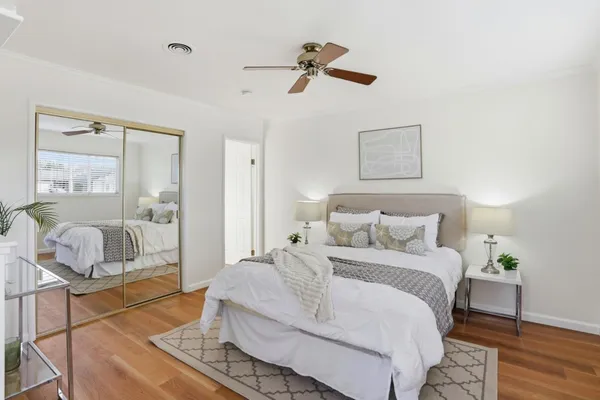 a bedroom with a bed and wooden floor