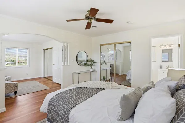 a bedroom with a bed a chandelier and dresser