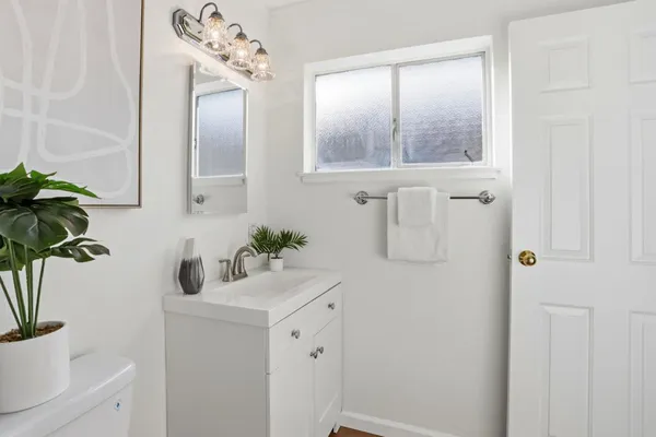 a bathroom with a sink a toilet and a mirror