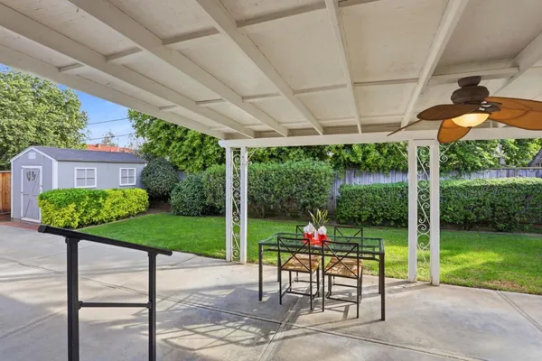 a view of a patio with a table chairs and a yard