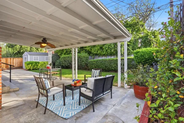 a view of a patio with table and chairs potted plants and palm tree