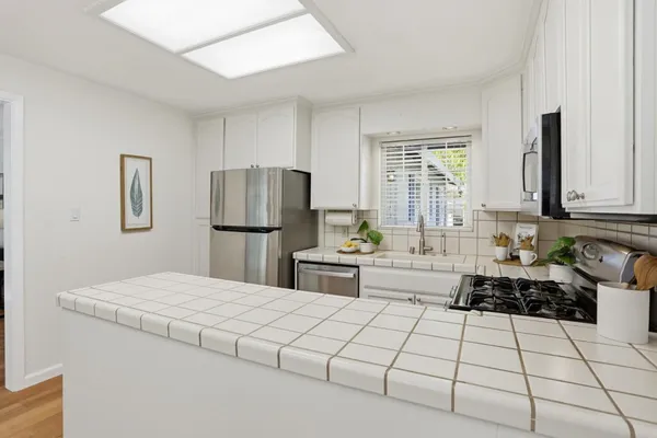a kitchen with stainless steel appliances a refrigerator sink and cabinets