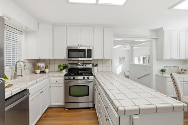 a kitchen with white cabinets stainless steel appliances and sink