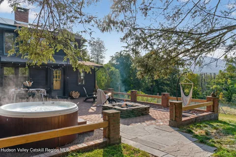 a view of a patio with table and chairs potted plants and large tree