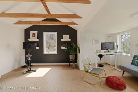a living room with furniture a window and gym equipment