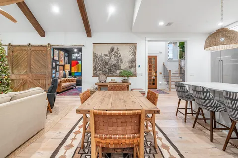 a large kitchen with stainless steel appliances a large counter top a sink and a chandelier