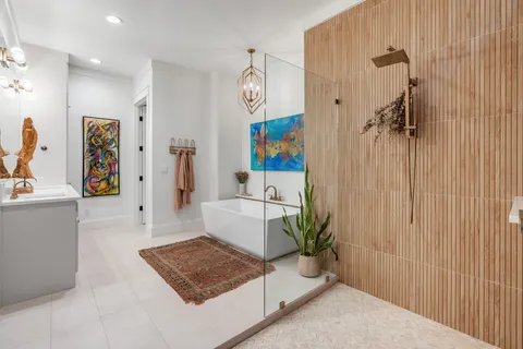 a bedroom with a bed couch and two windows