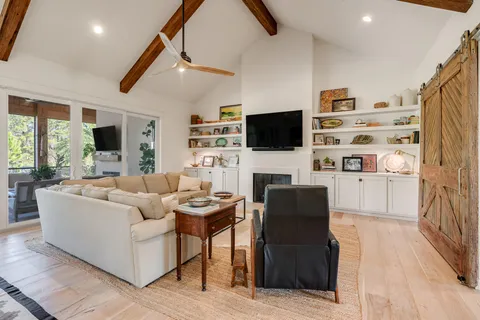 a living room with furniture a flat screen tv and a fireplace