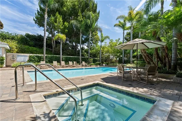 a view of a swimming pool with lawn chairs under an umbrella