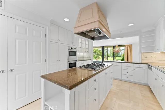 a kitchen with granite countertop stainless steel appliances a stove sink and cabinets