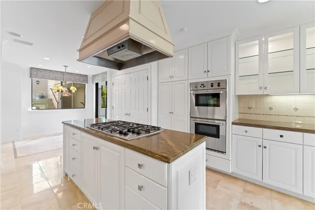 a kitchen with stainless steel appliances kitchen island granite countertop a stove a sink and a refrigerator