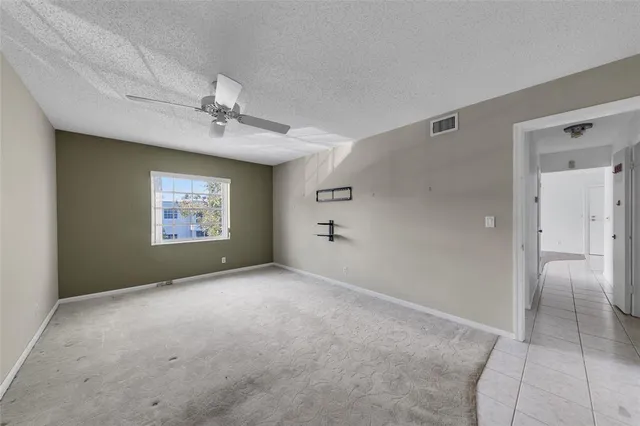 a view of an empty room with a ceiling fan