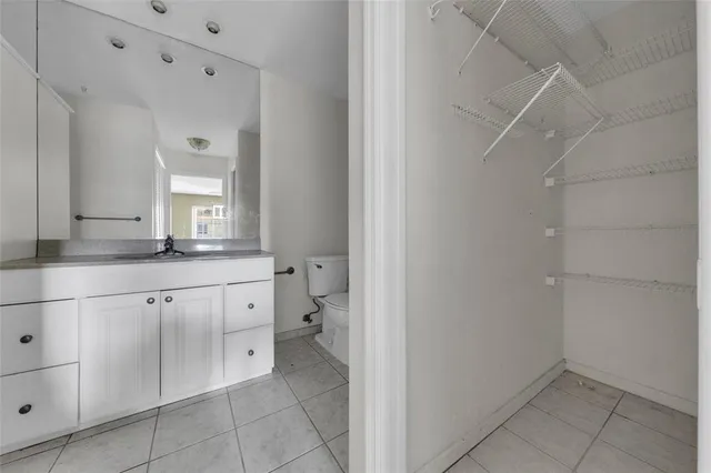 a bathroom with a granite countertop sink a toilet and shower
