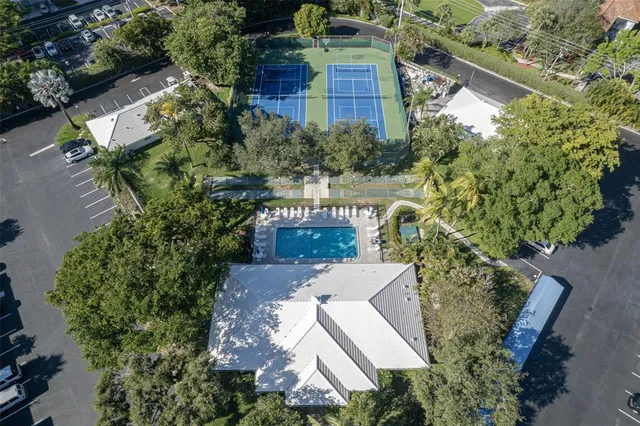 an aerial view of a house with a yard and large trees