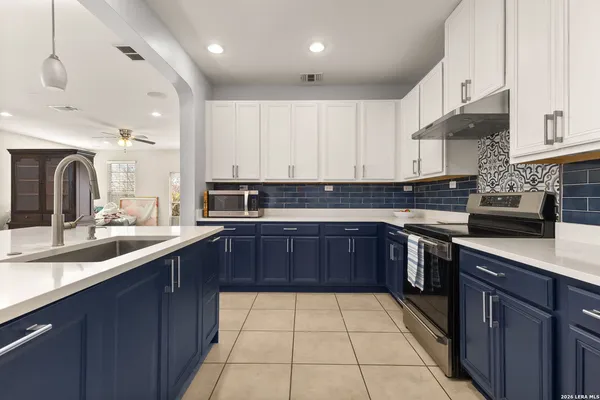 a kitchen with a sink a refrigerator and chairs