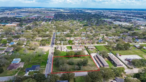 an aerial view of residential houses with outdoor space and trees