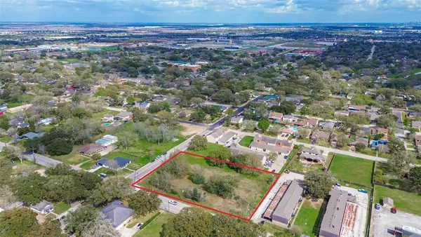 an aerial view of residential houses with outdoor space and trees