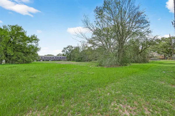 a view of a green field with wooden fence