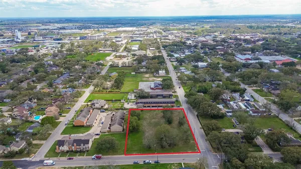 an aerial view of residential houses with outdoor space and trees