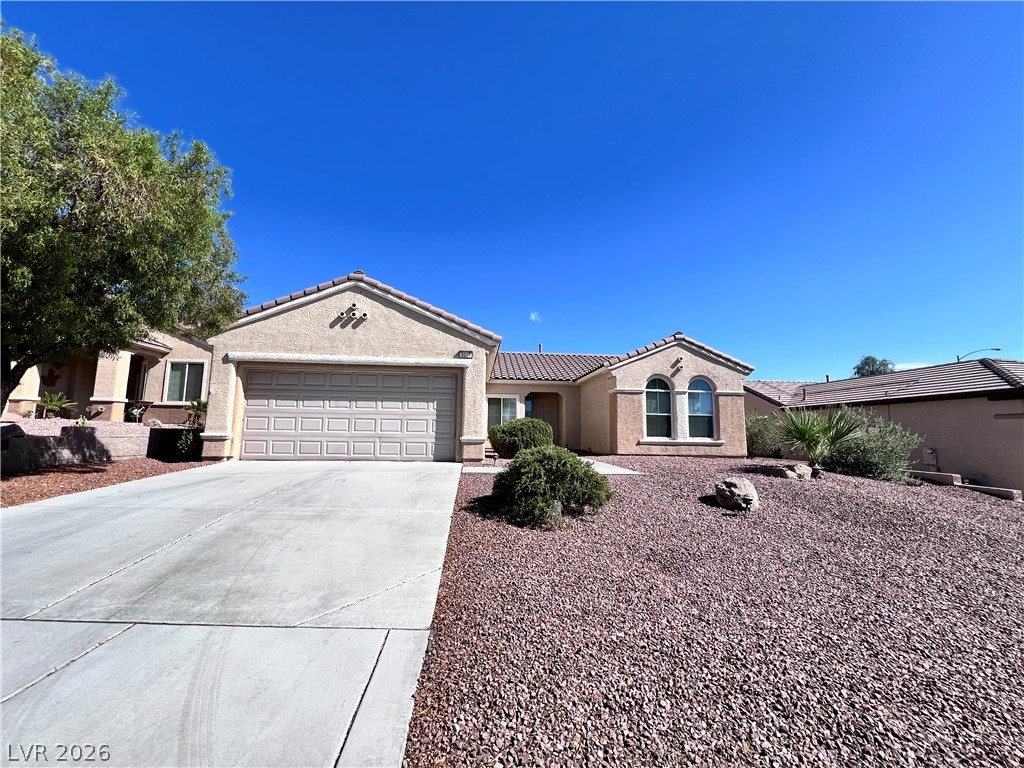 3047 Hickory Valley Road Henderson, NV 89052 - Photo 31 of 33 A well-maintained desert landscape frames this welcoming residence, complete with an attached garage.