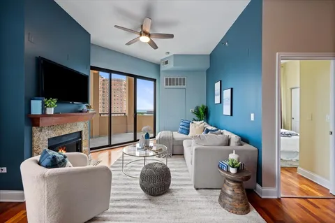 a living room with furniture a flat screen tv and a fireplace