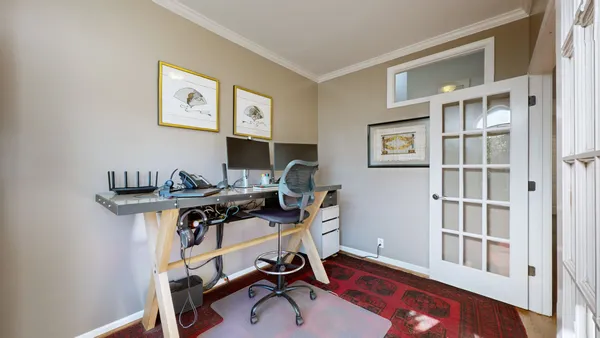 a view of a workspace with furniture and a window