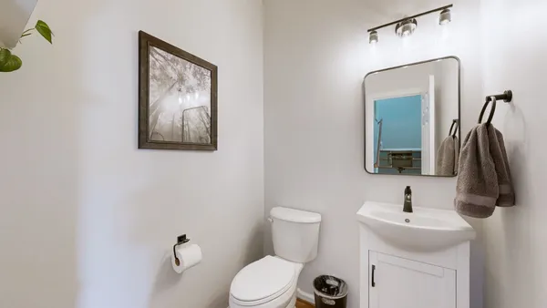 a bathroom with a toilet sink and mirror