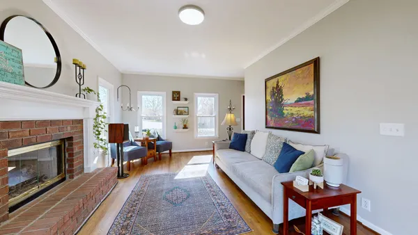 a living room with furniture a fireplace and a wall painting