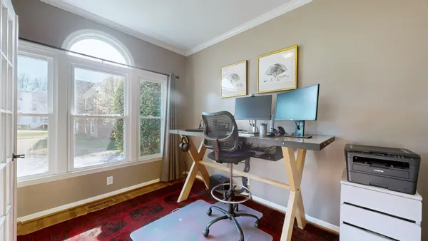 a view of a workspace with furniture and a window