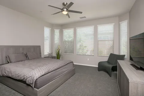 a bedroom with a large bed couch and a large window