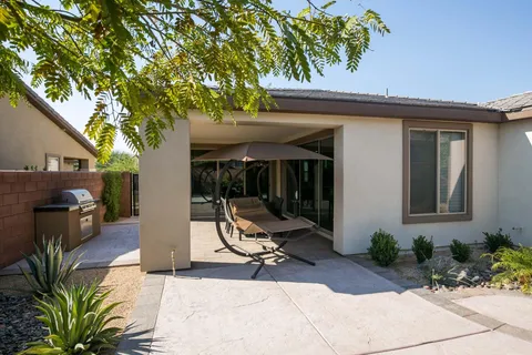 a view of backyard with a table and chairs under an umbrella
