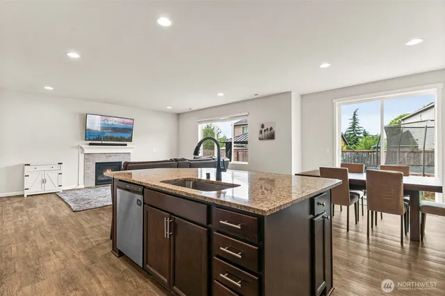 a dining hall with stainless steel appliances granite countertop a sink and a refrigerator