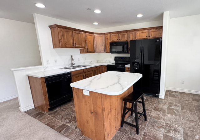 909 South Main Street, Unit F Layton, UT 84041 - Photo 2 of 21 Kitchen featuring wood cabinetry, white stone-look countertops, and black appliances including a refrigerator, microwave, range, and dishwasher